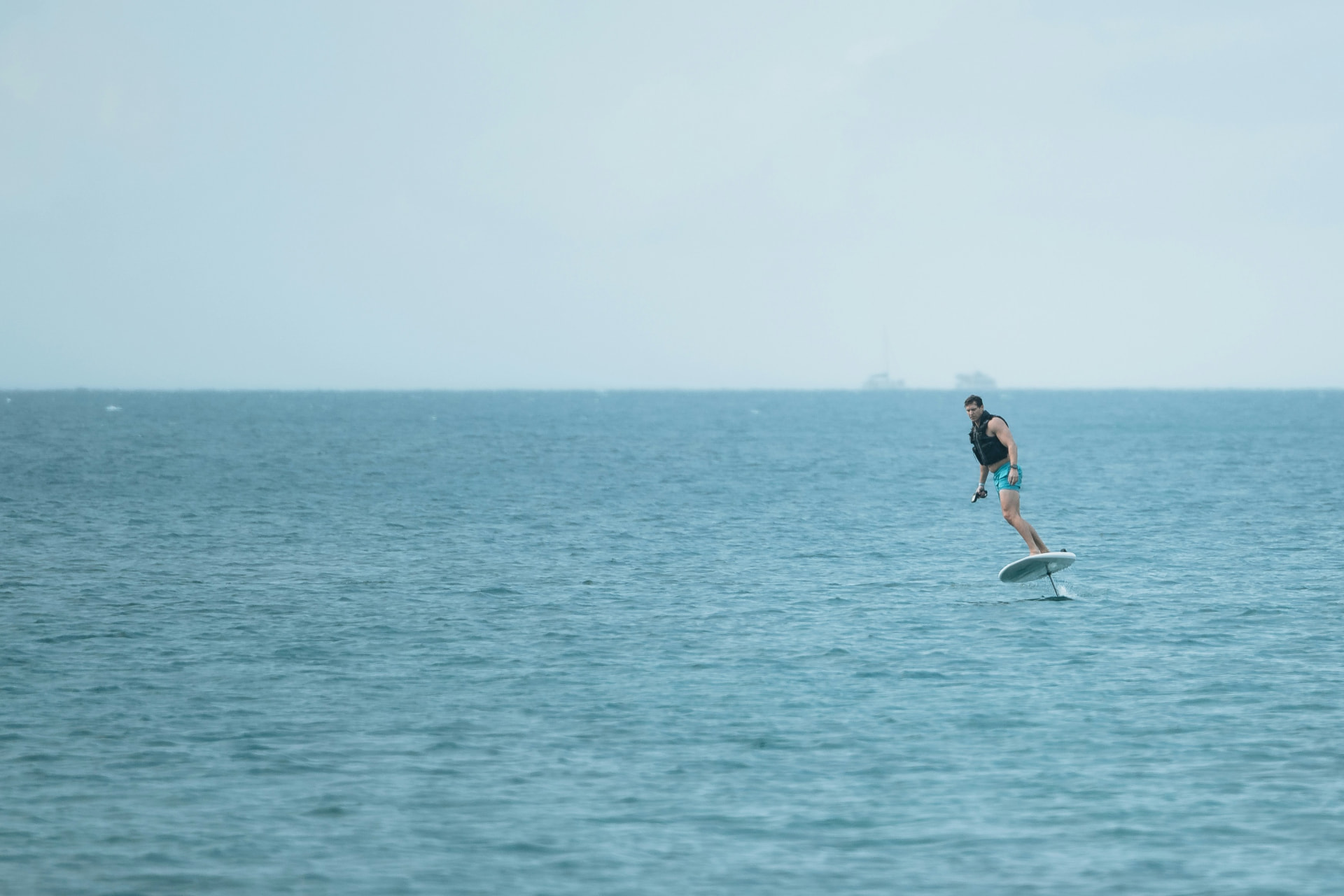 A rider foiling across open water on an electric hydrofoil board